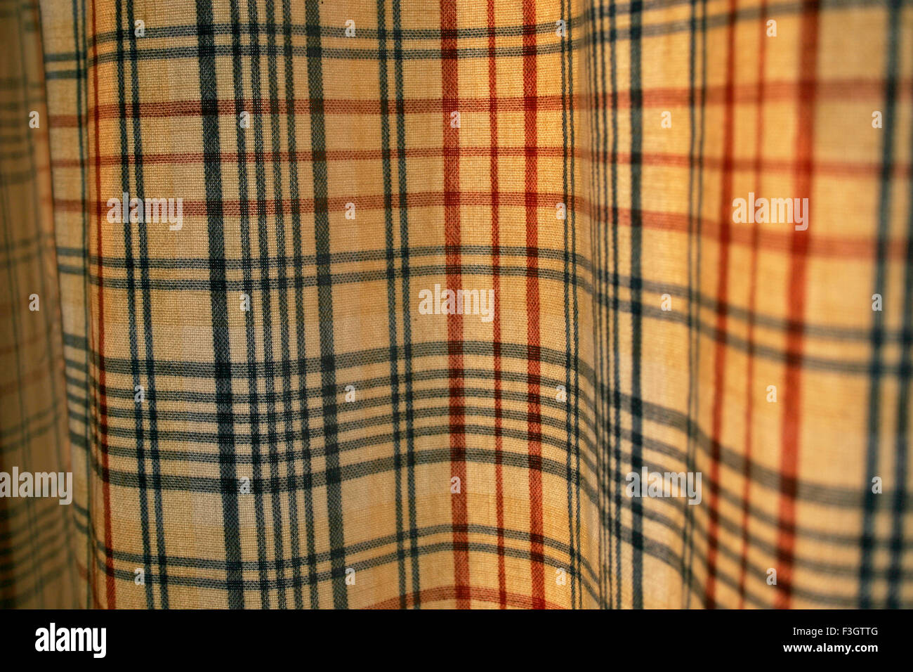 Zusammenfassung der gelbe Vorhang rot und blau Kontrollen und seinen Stoff Textur und Falten; Pune; Maharashtra; Indien Stockfoto