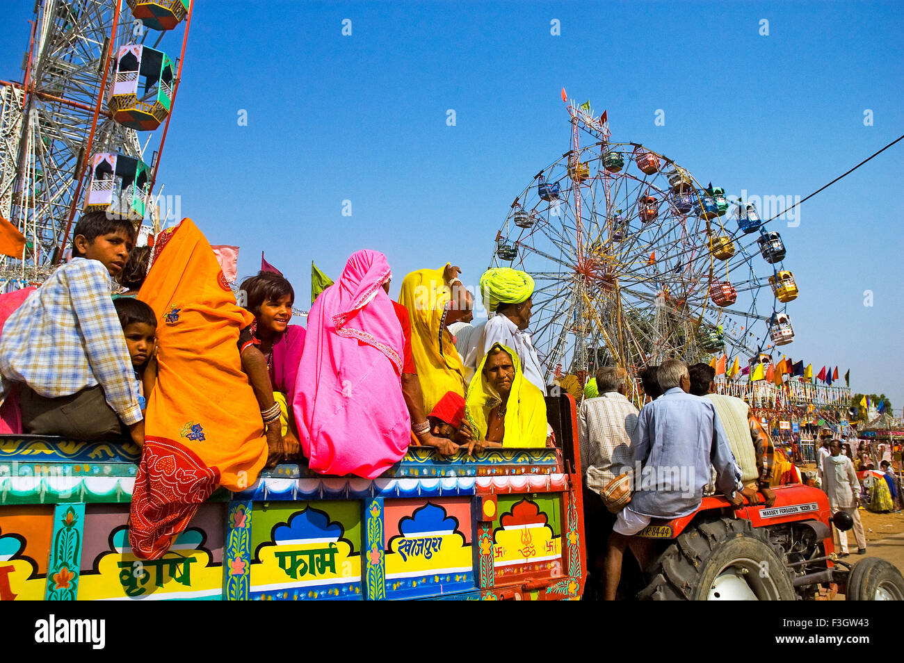 Gruppe von Dorfbewohnern in bunten Kleidern kommen auf Traktor, jährliche Pushkar Viehmarkt; Pushkar; Rajasthan; Indien Stockfoto