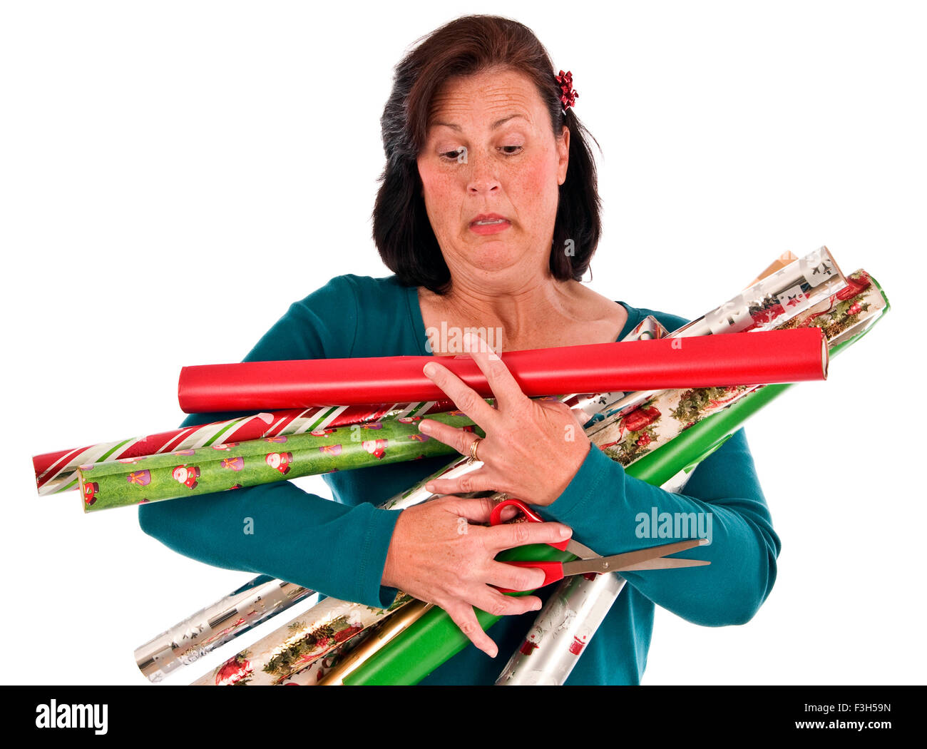Eine Frau entdeckt, dass sie zu viele Rollen Weihnachten Geschenkpapier zu tragen hat Stockfoto