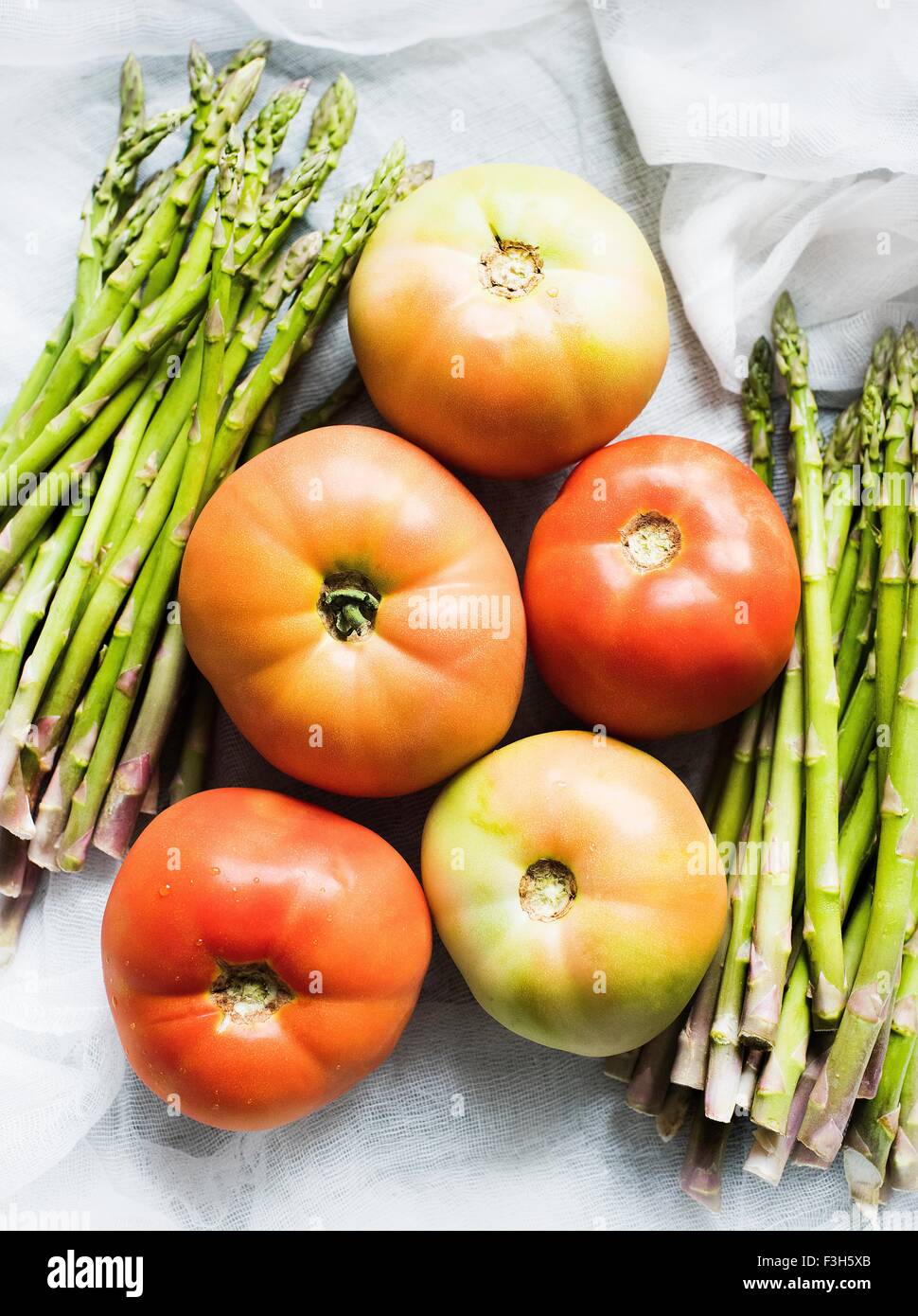 Stillleben mit Spargel und Tomaten auf Musselin Stockfoto