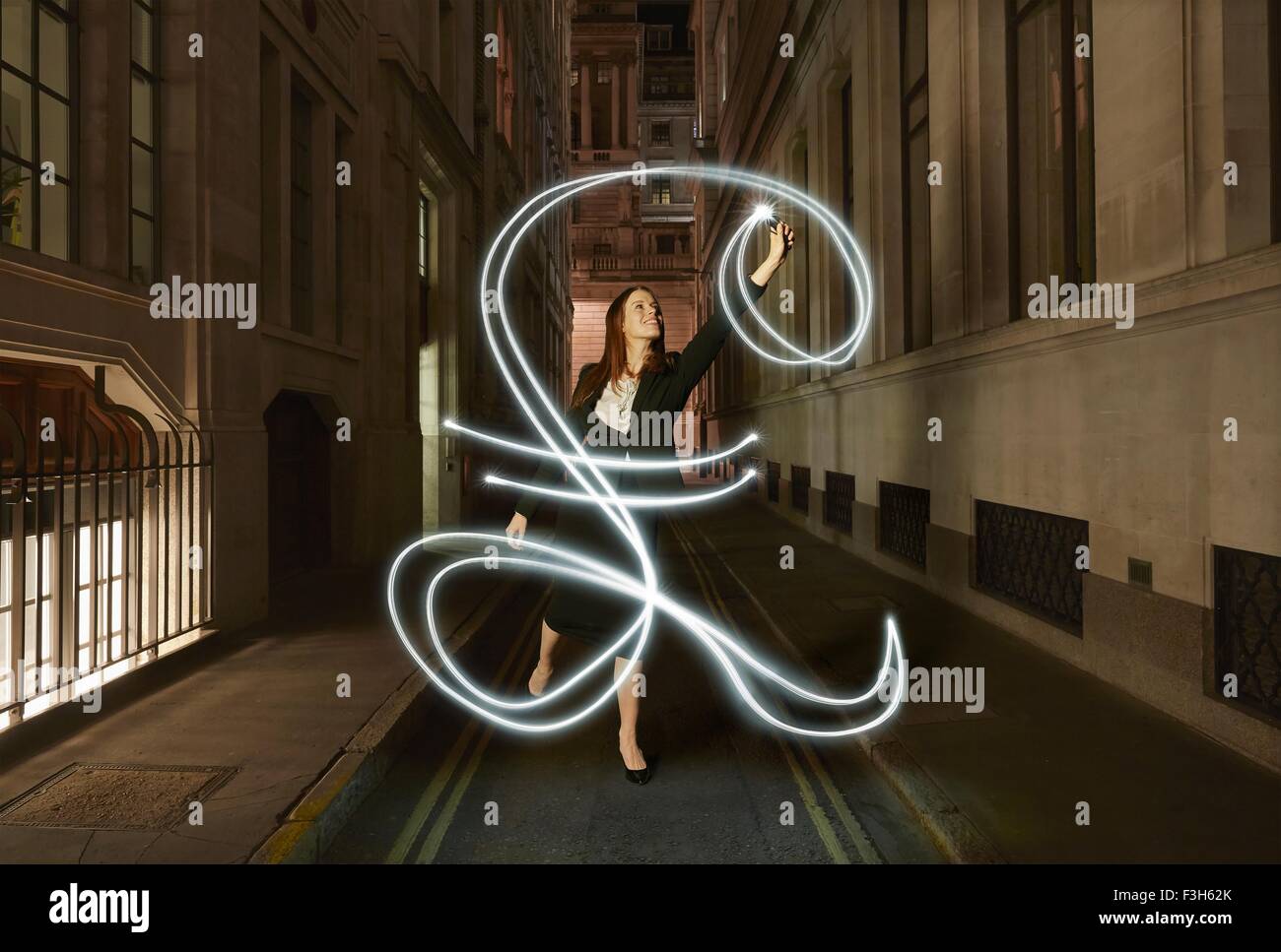 Geschäftsfrau Lichtmalerei glühende Pfund anmelden Stadtstraße in der Nacht Stockfoto
