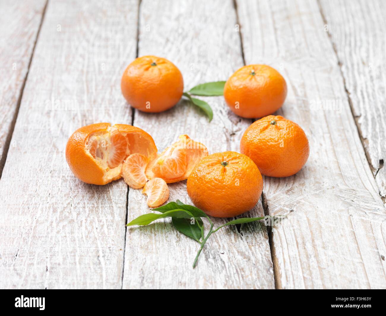Mandarinen geschält und ganz auf weiß getünchten Holztisch Stockfoto
