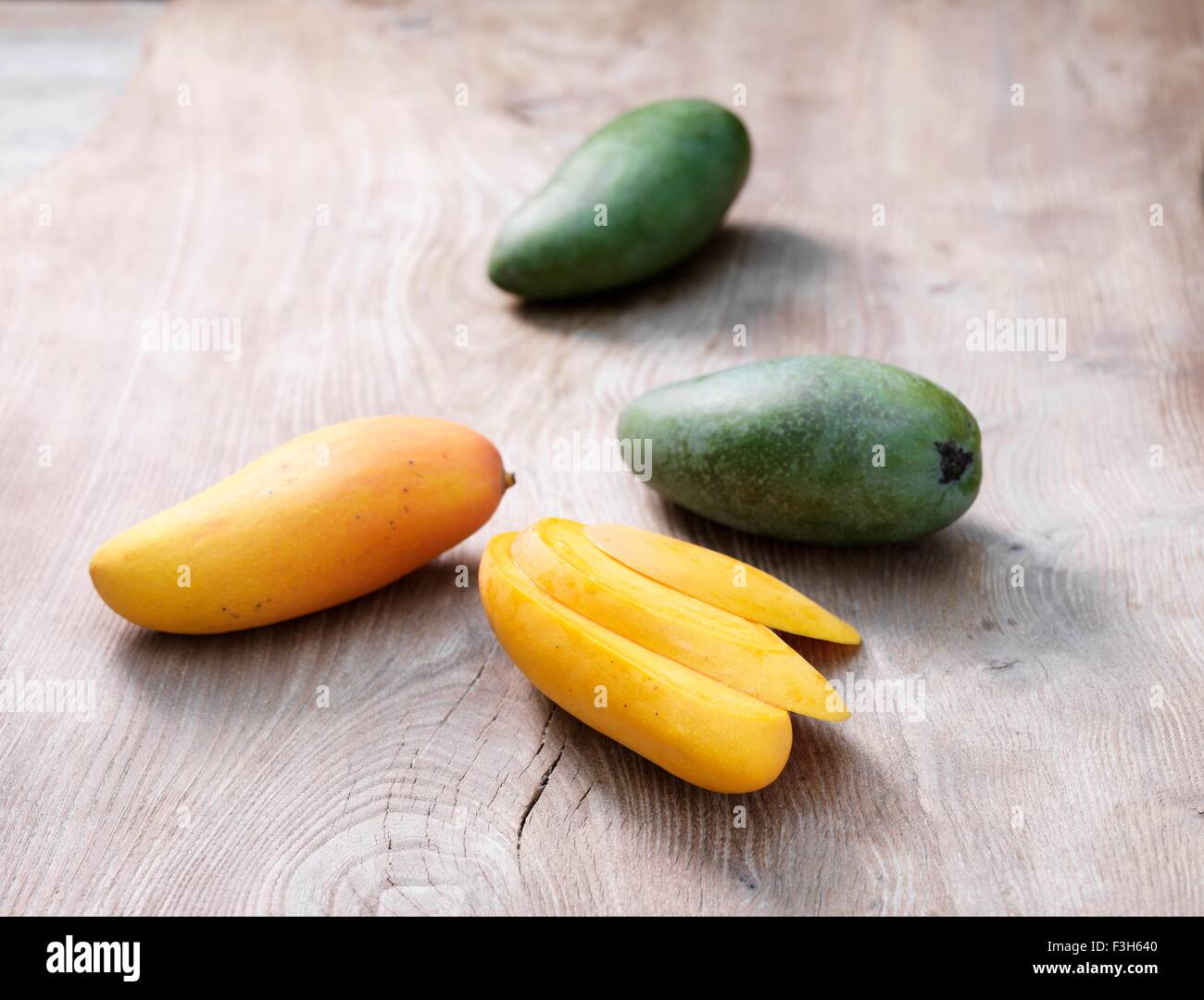 Mango in Scheiben geschnitten und ganze auf weiß getünchten Holztisch Stockfoto