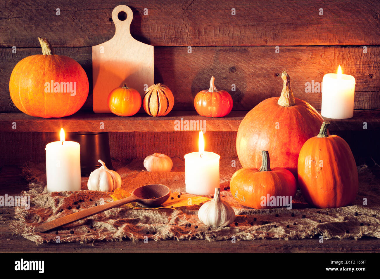 Kürbisse auf einem Holztisch mit Zubehör für die Küche Stockfoto
