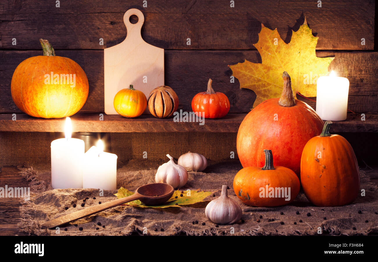 Kürbisse auf einem Holztisch mit Zubehör für die Küche Stockfoto