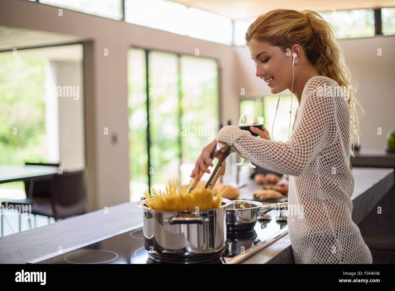 Junge Frau, die kochen Spaghetti in Küche Stockfoto