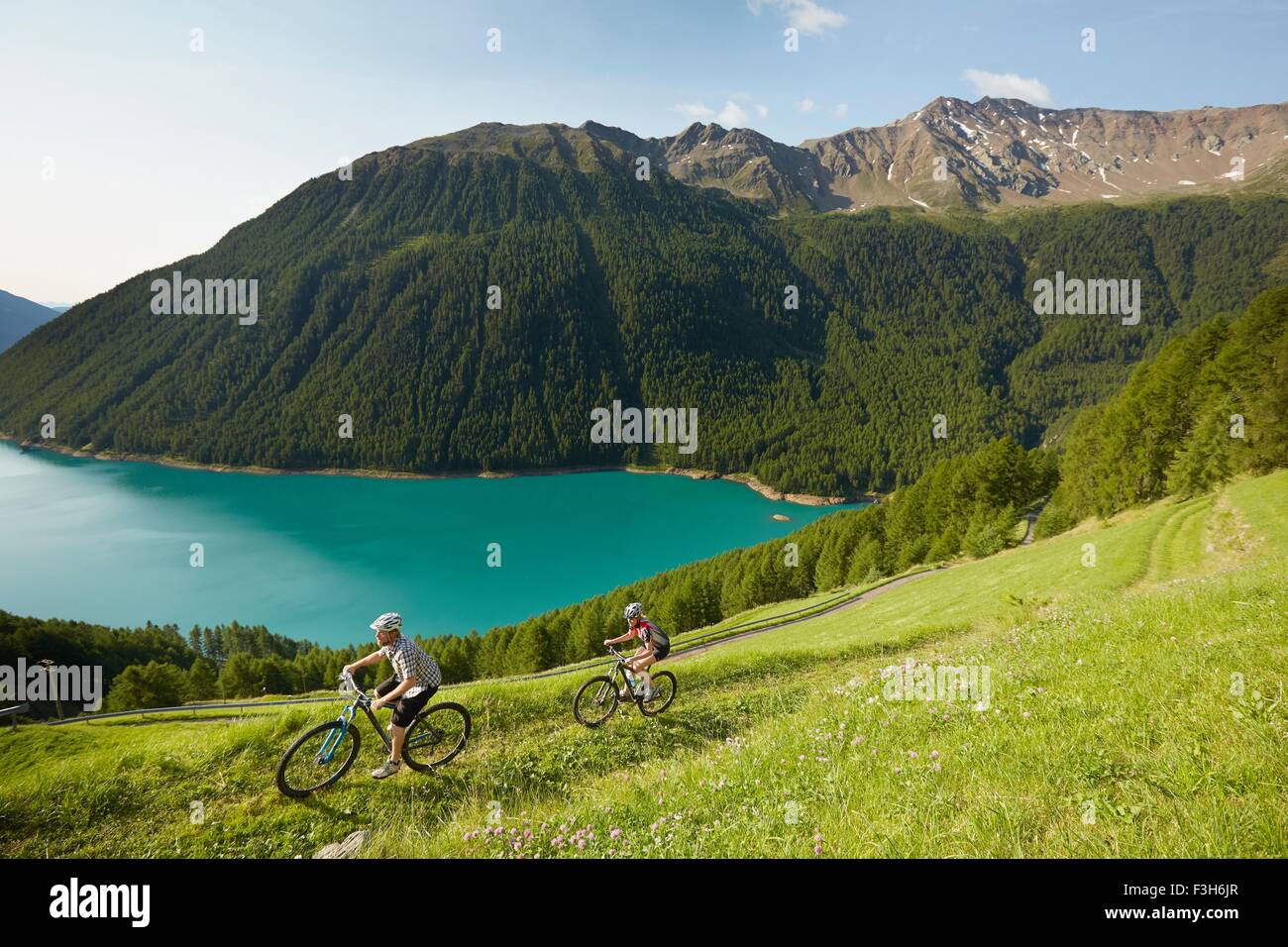 Junges Paar Mountainbiken am Vernagt Stausee, Val Senales, Südtirol, Italien Stockfoto