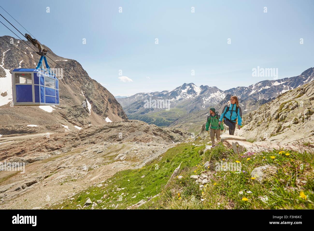 Junge Wandern paar und Seilbahn am Val Senales Glacier, Val Senales, Südtirol, Italien Stockfoto
