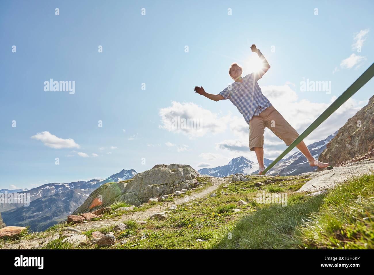 Junger Mann, balancieren auf der Slackline in Val Senales Glacier, Val Senales, Südtirol, Italien Stockfoto
