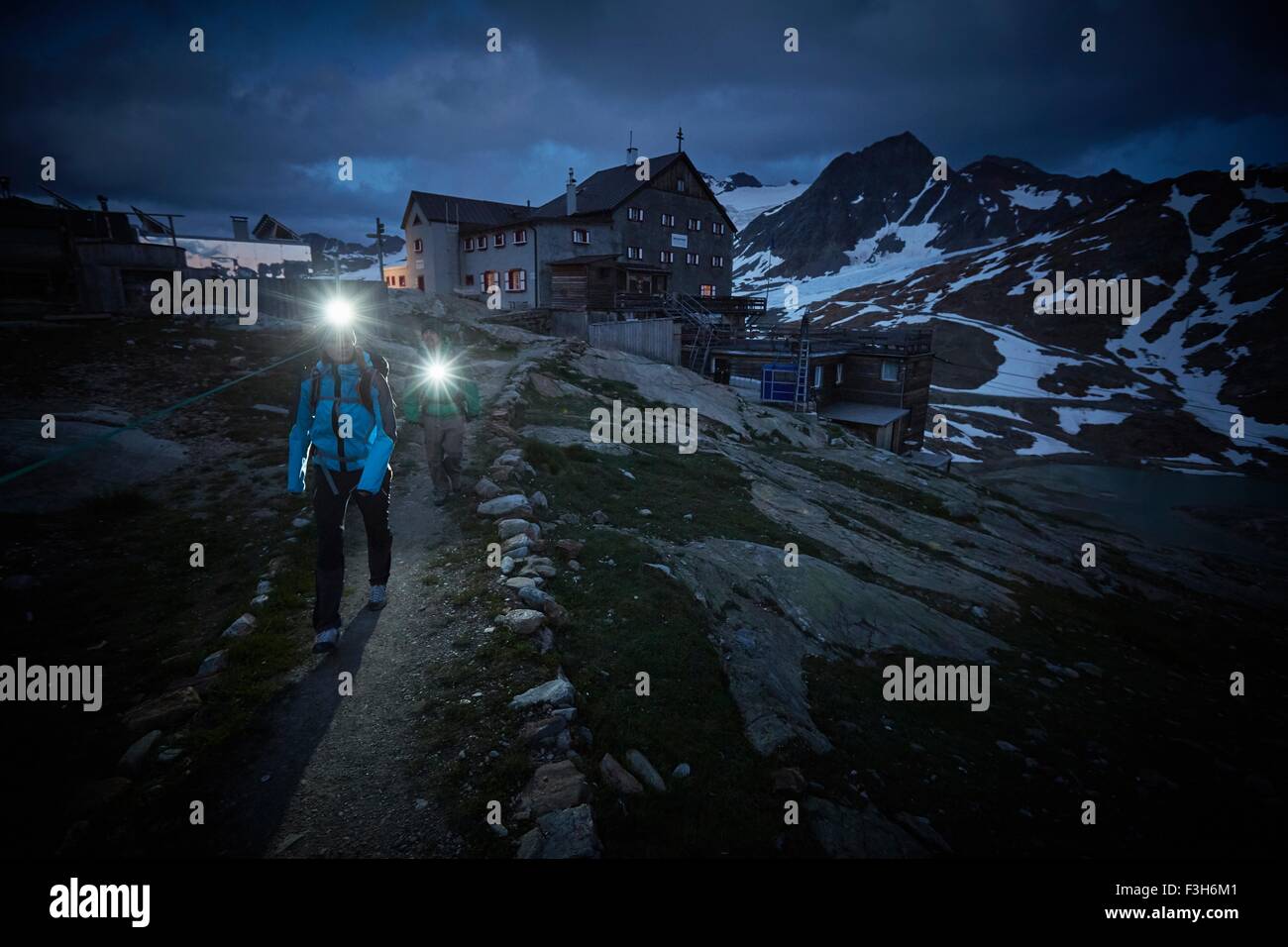 Junges Paar wandern nachts tragen Scheinwerfer auf Weg in Val Senales Glacier, Val Senales, Südtirol, Italien Stockfoto