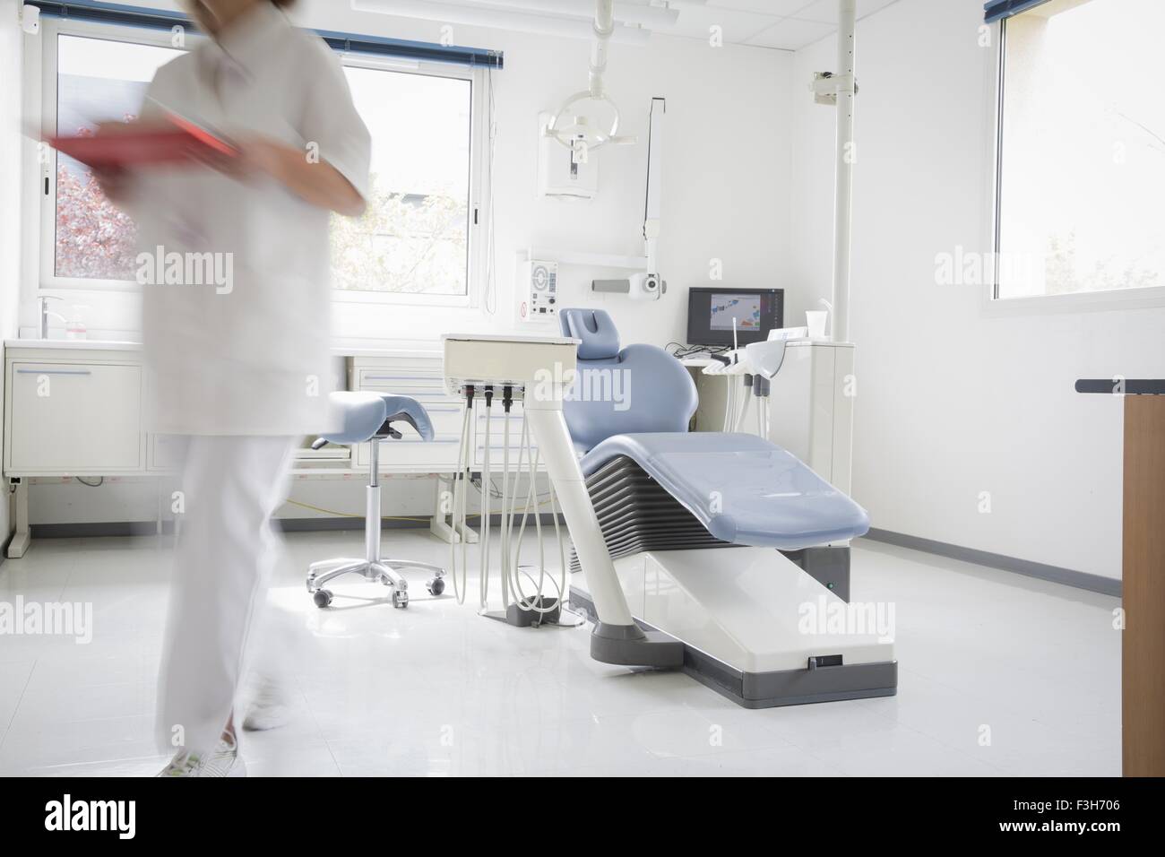 Zahnarztstuhl, Zahnarzthelferin zu Fuß entfernt, Bewegungsunschärfe Stockfoto