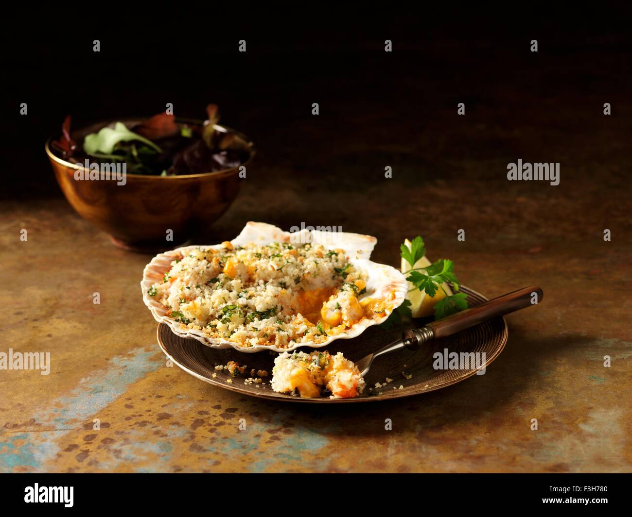 Stillleben mit Langusten und Garnelen Backen im Seashell mit gemischtem Salat Stockfoto