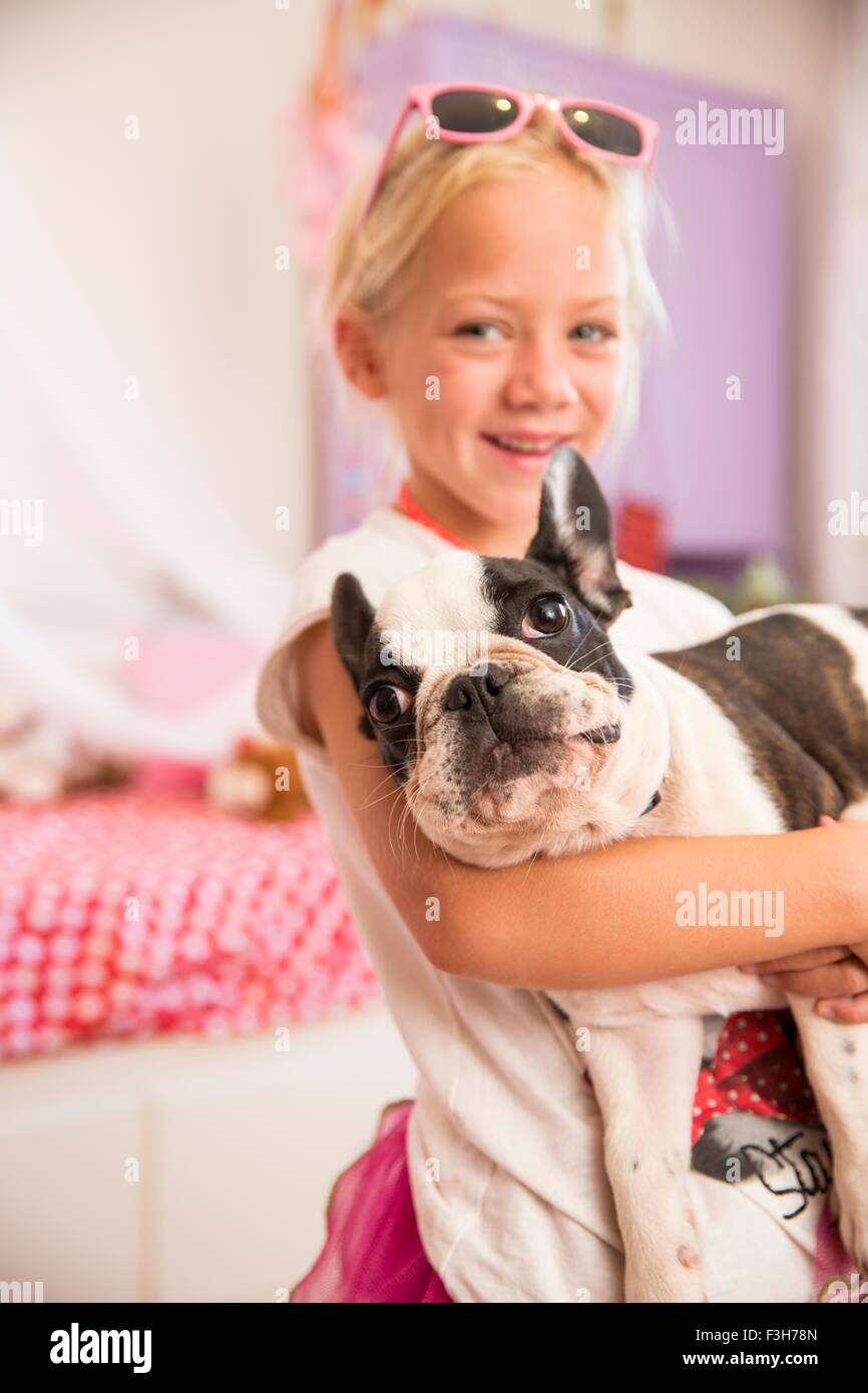 Porträt eines Mädchens mit niedlichen Hund im Schlafzimmer Stockfoto