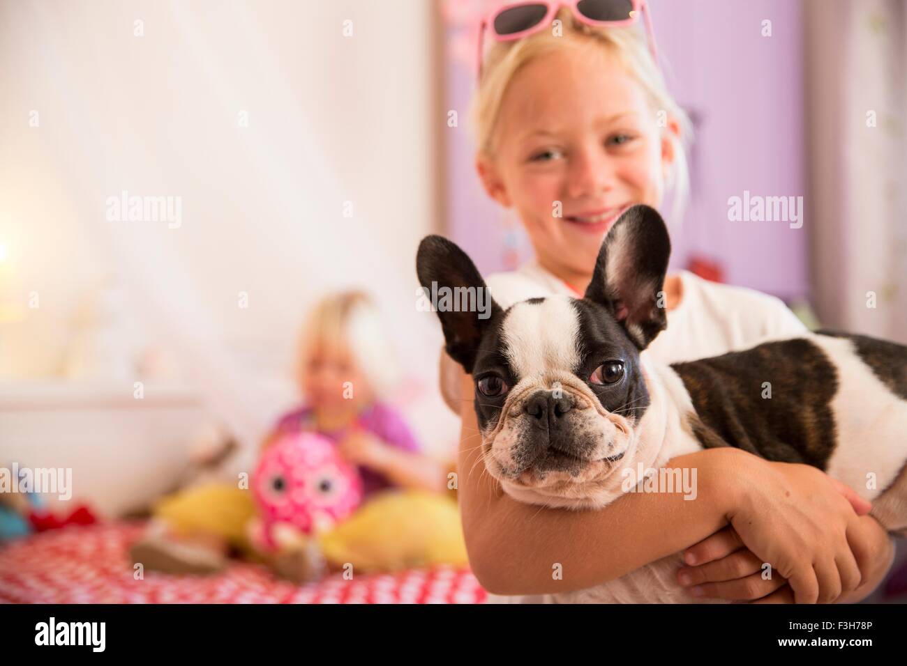Porträt von Mädchen und niedlichen Hund im Schlafzimmer Stockfoto