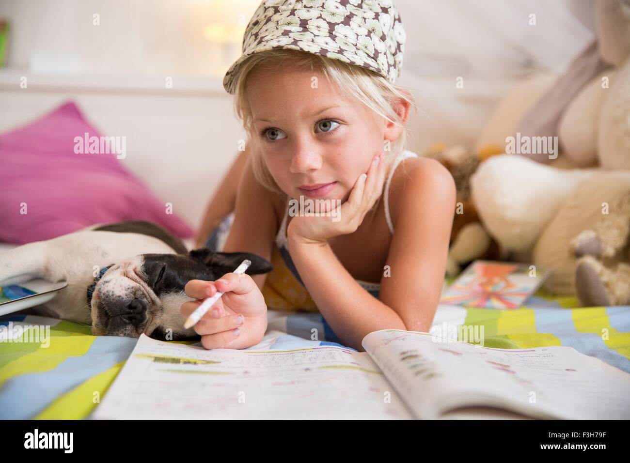 Mädchen auf Bett spielen mit Puzzle-Buch Stockfoto