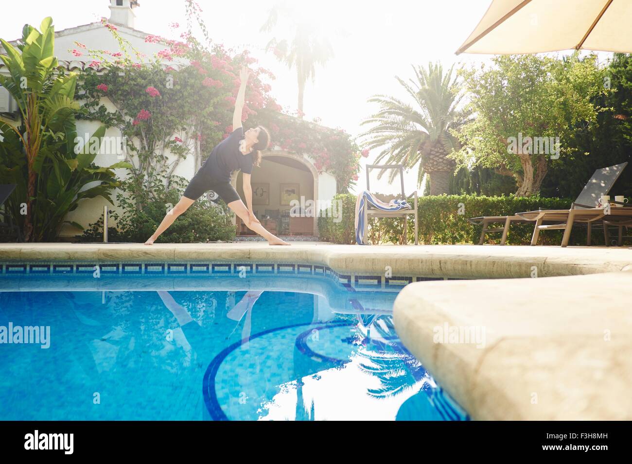 Reife Frau beim Yoga am Pool Ferienwohnung Stockfoto
