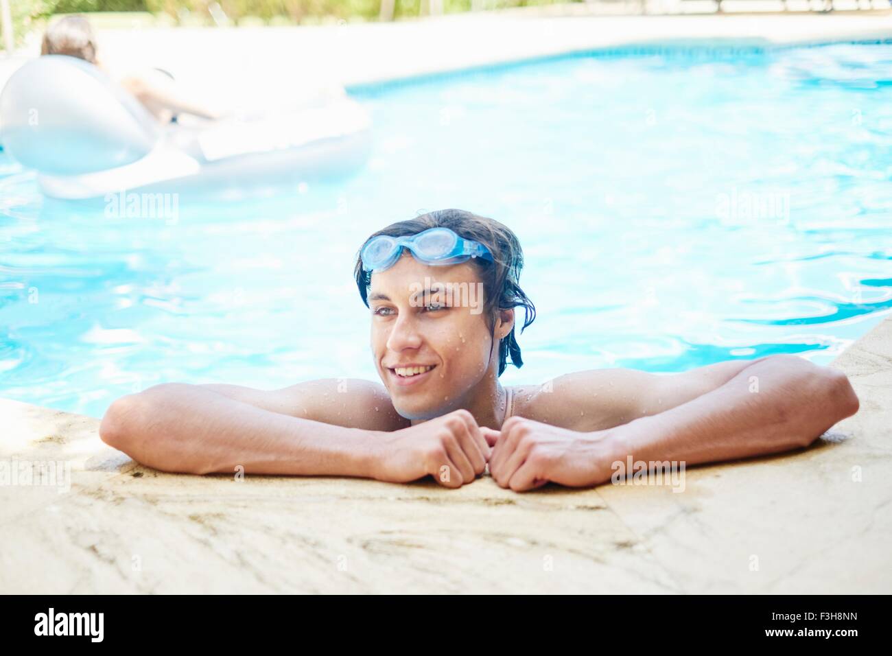 Porträt von lächelnden jungen Mann mit nassen Haaren im Schwimmbad Stockfoto
