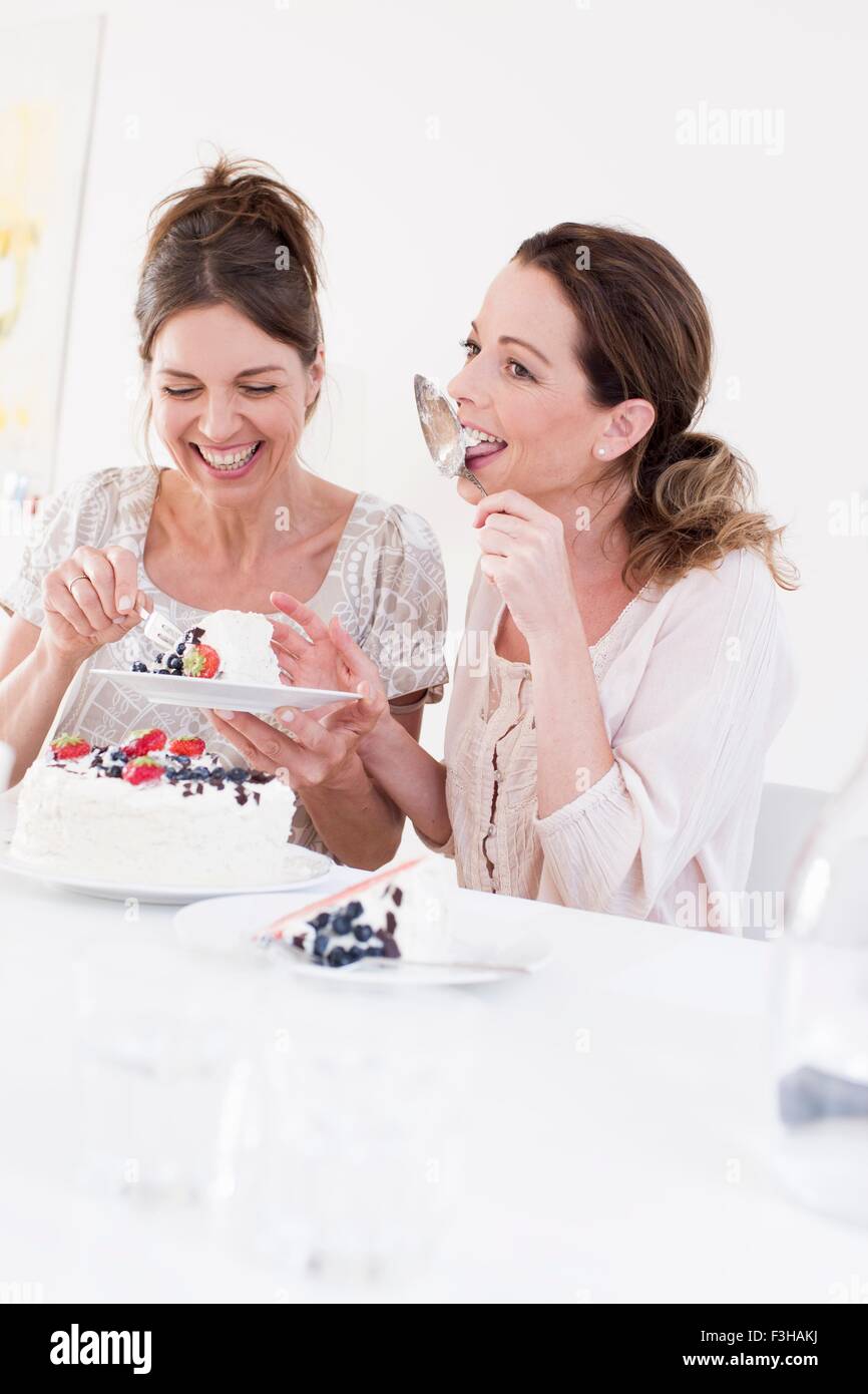 Reife Frau essen Kuchen, lecken Tortenheber lächelnd Stockfoto