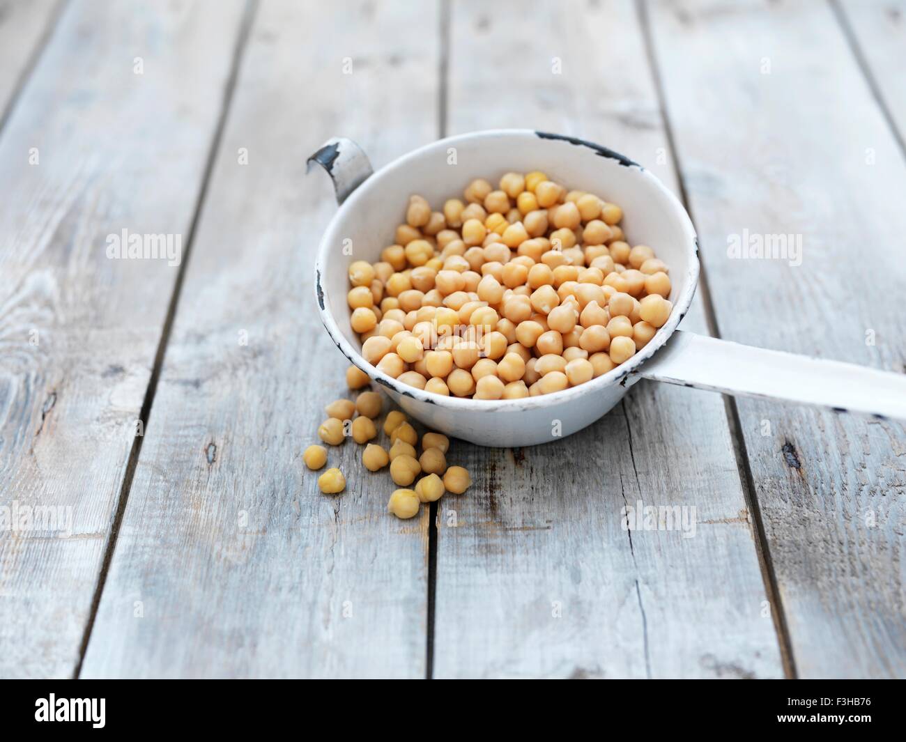 Stillleben mit Kichererbsen (auch bekannt als Gramm, Bengal Gramm, Kichererbsen, Garbanzo Bohnen und ägyptischen Erbsen) in Emaille-Topf Stockfoto