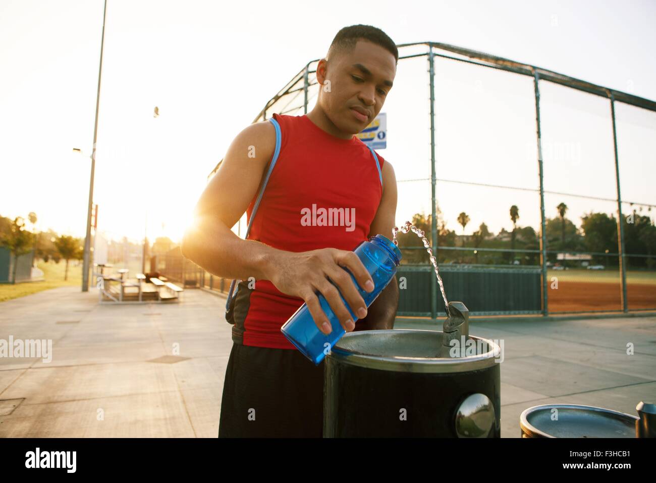 Junger Mann Füllung Wasserflasche aus Getränke Brunnen Stockfoto