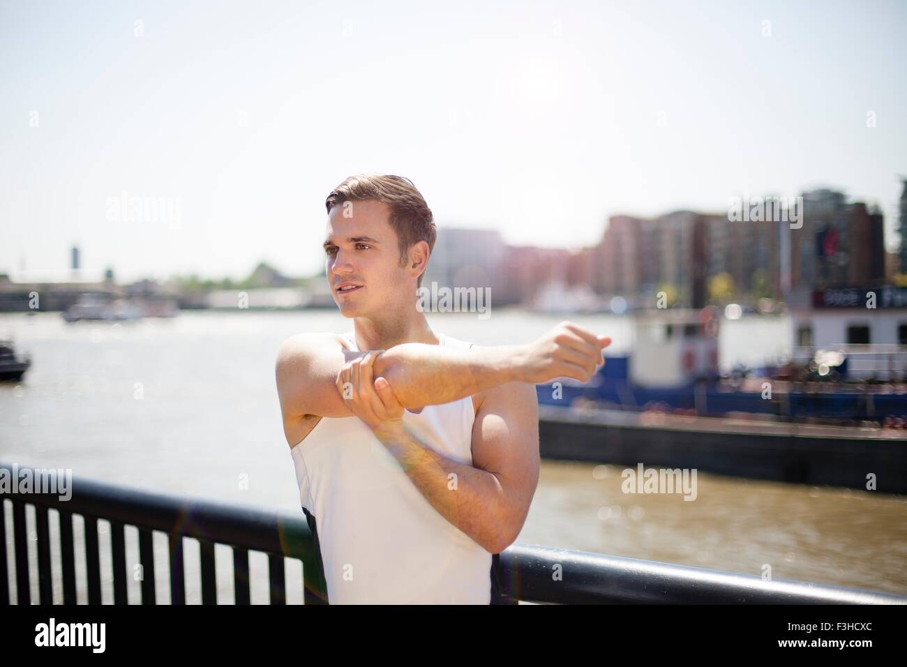 Läufer, die Dehnung am Flussufer, Wapping, London Stockfoto