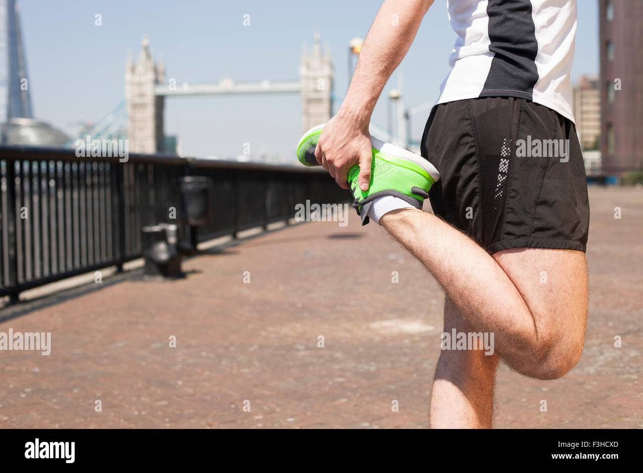 Läufer, die Dehnung am Flussufer, Wapping, London Stockfoto