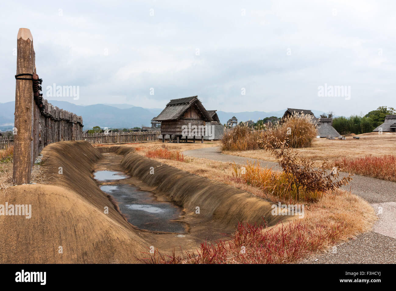 Yoshinogari Park, Japan. Yayoi rekonstruiert Siedlung. Minami no Mura, South Village. Abstellraum und das Dorf vom Eingang mit Wassergraben und Holzzaun. Stockfoto