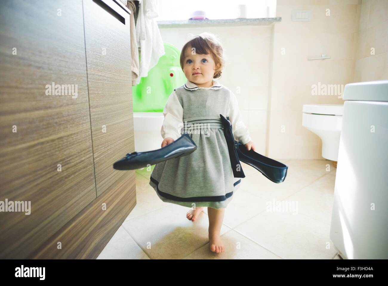 Weiblichen Kleinkind tragen Damenschuhe zu Hause Stockfoto