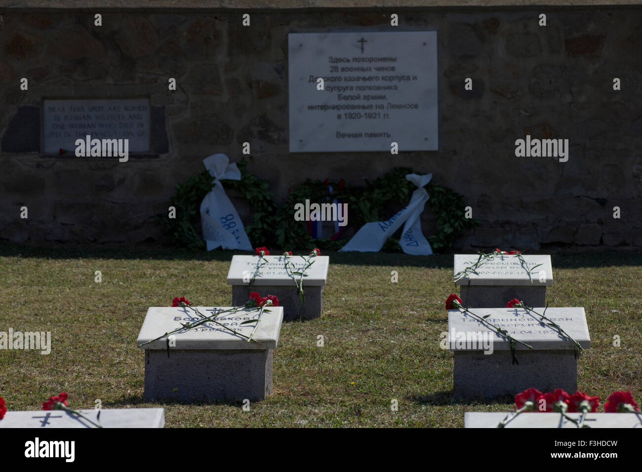 Nelken auf Grabsteinen in den russischen Teil der CWGC Osten Mudros Soldatenfriedhof. Russische Plaque und Kränze sichtbar. Stockfoto