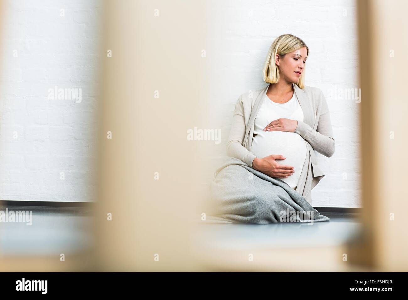 Volle Amtszeit Schwangerschaft junge Frau am Boden Stockfoto