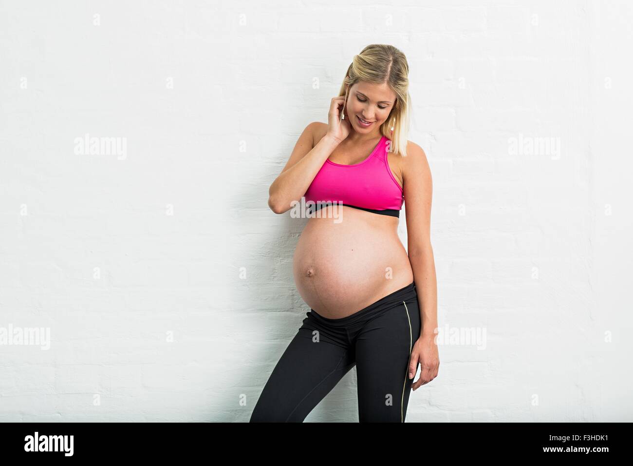 Volle Amtszeit Schwangerschaft junge Frau trägt Sportbekleidung Stockfoto