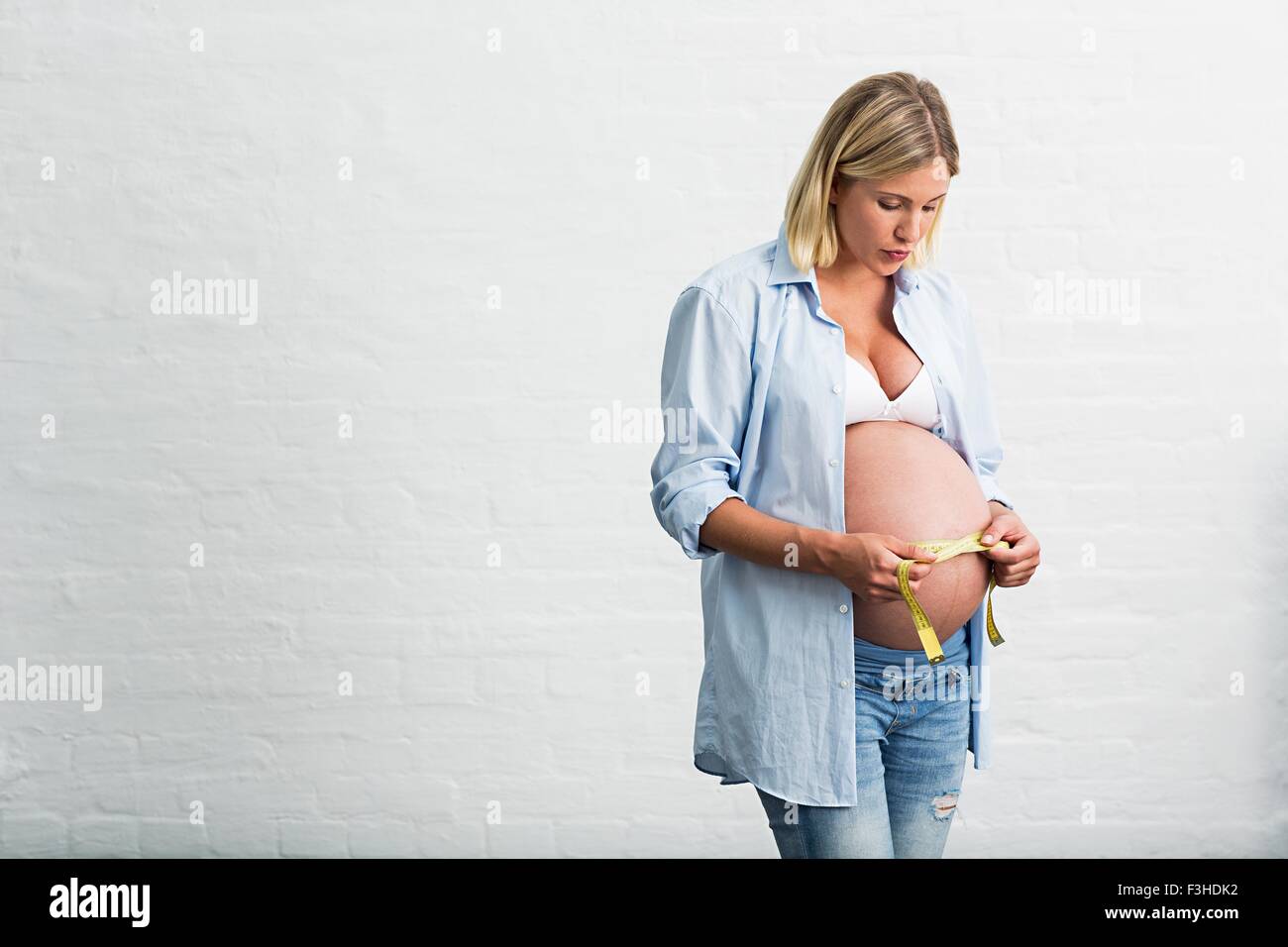 Volle Amtszeit Schwangerschaft junge Frau Bauch messen Stockfoto