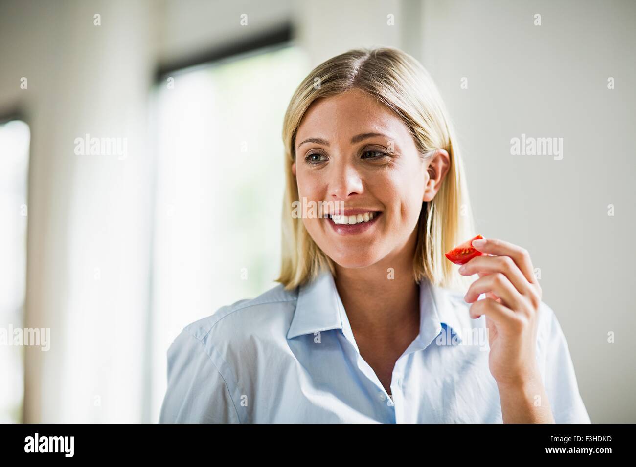 Junge Frau Essen Tomaten sllice Stockfoto