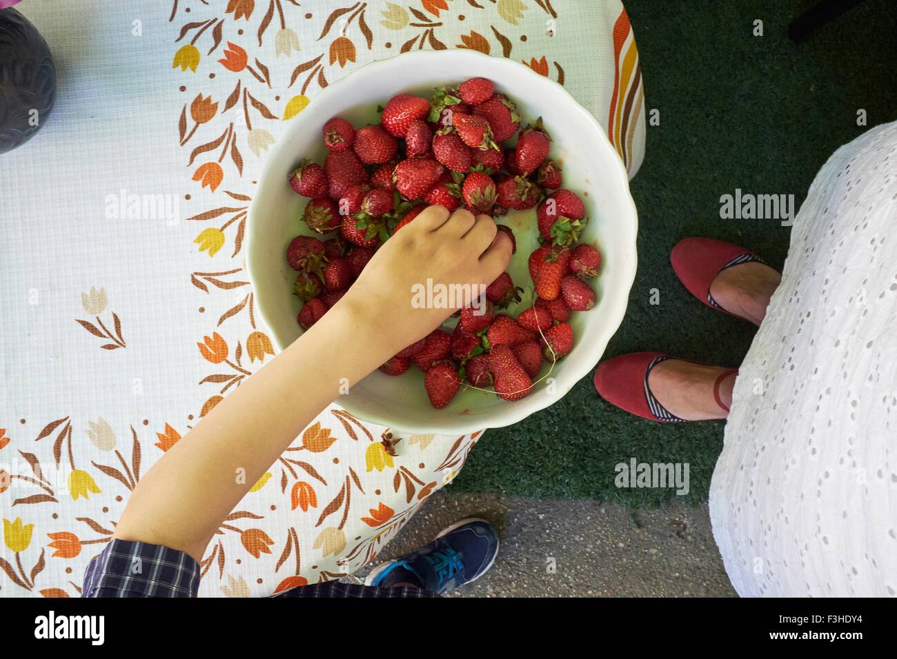 Draufsicht der jungen Hand frischen Erdbeere aus Schüssel Abholung Stockfoto