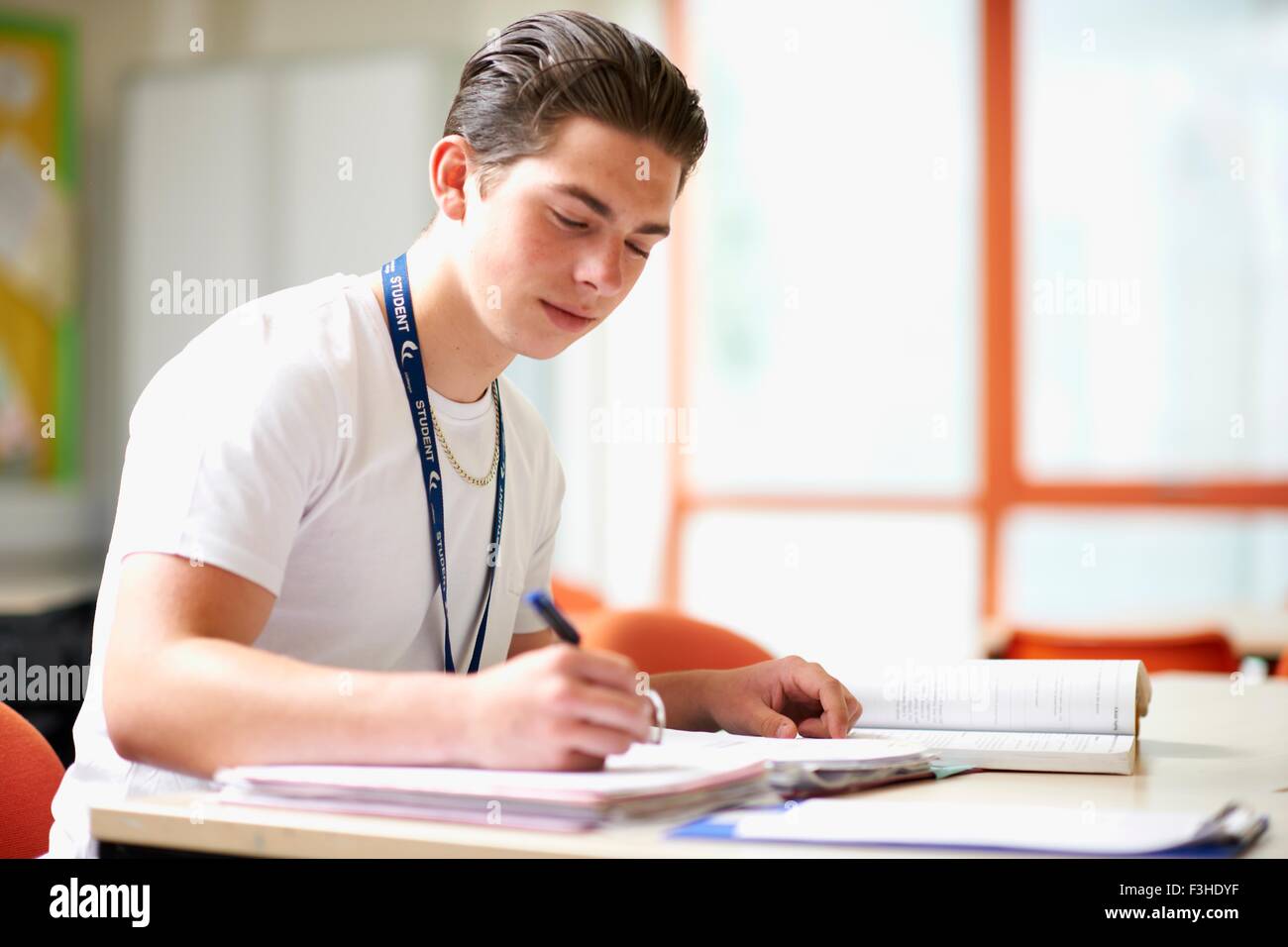 Männliche Teenager-Studentin in Datei schreiben Stockfoto