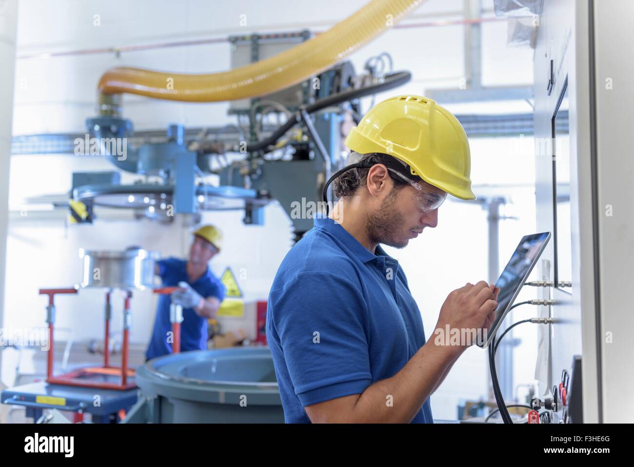 Arbeiter, die Umwelt Prüfgeräte mit digital-Tablette in Elektronik-Fabrik in Betrieb Stockfoto