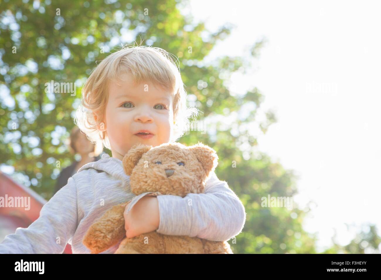 Porträt von niedlichen weiblichen Kleinkind umarmen Teddybär auf Rutschbahn Stockfoto