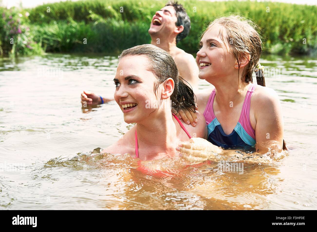 Zwei Schwestern und Freund im ländlichen See schwimmen Stockfoto