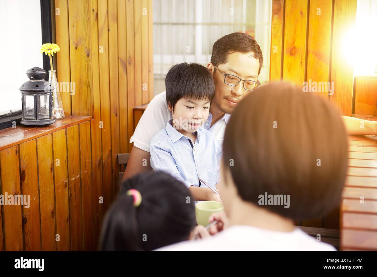 Junge chinesische Familie frühstücken auf dem Balkon in der Sonne zusammen Stockfoto