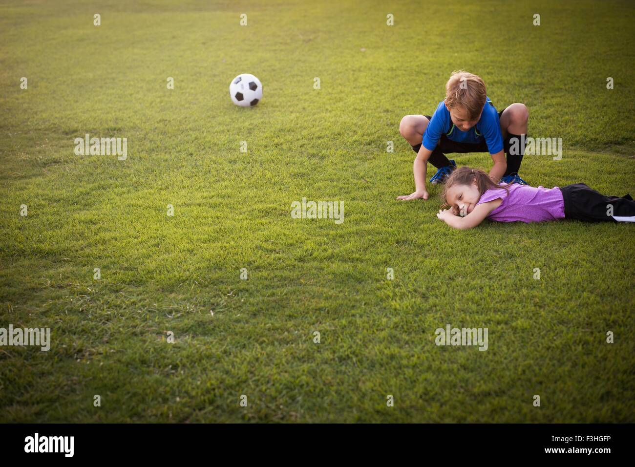 Junge Pflege verletzt jüngere Schwester auf Praxis Fußballplatz Stockfoto