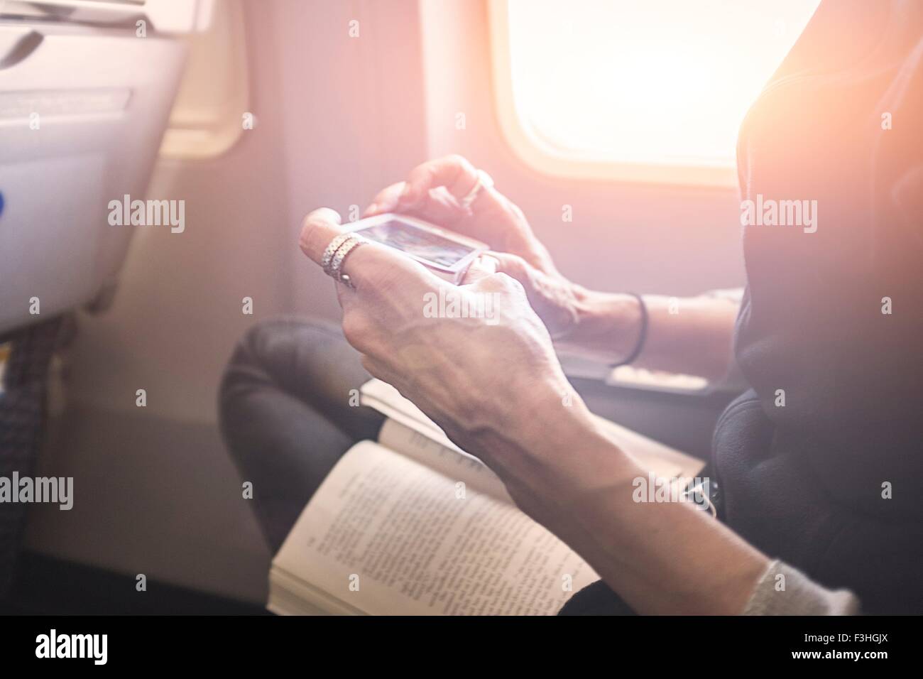 Auf Smartphone an Bord Flugzeug Spiel spielt Stockfoto