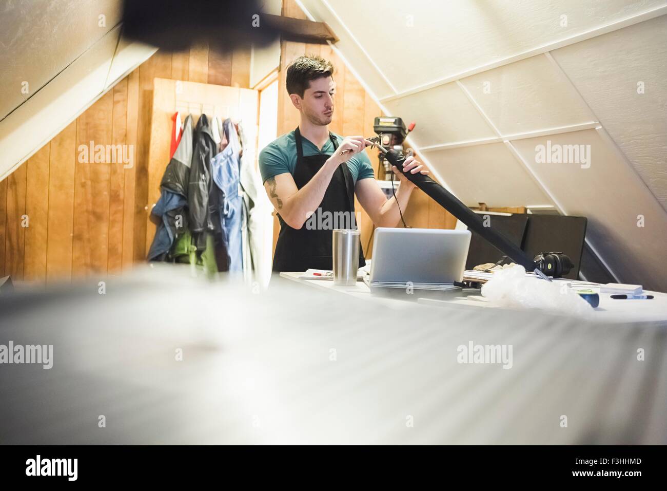 Ebene Oberflächenansicht von junger Mann in der Werkstatt fertigen Objekt mit Werkzeug Stockfoto
