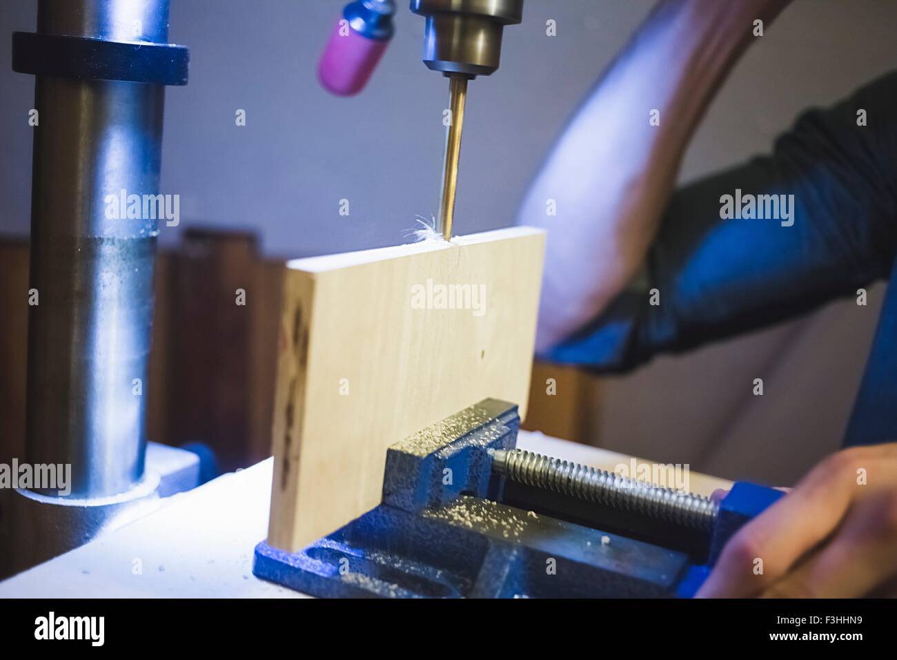 Verkürzte Sicht junger mans Hand Bohrmaschine auf Holz in Klammer in Betrieb Stockfoto
