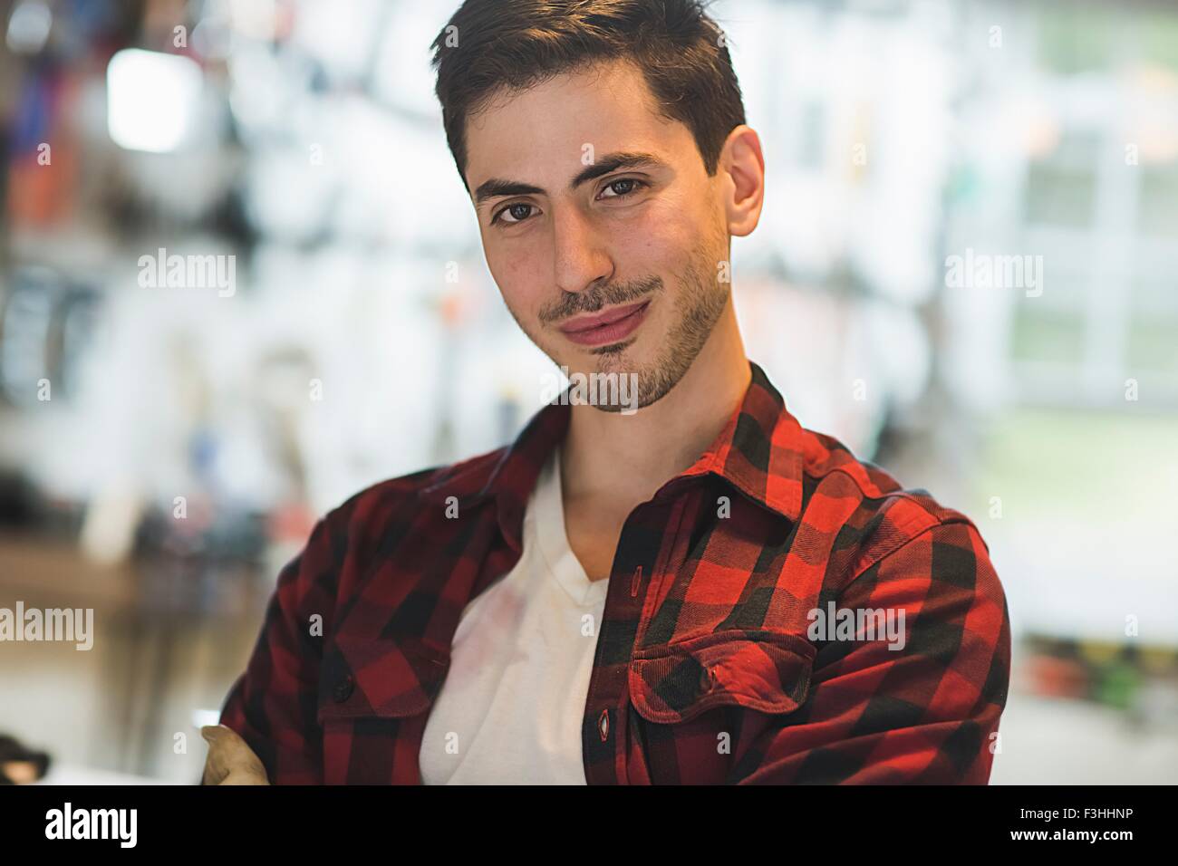 Porträt des jungen Mannes tragen überprüft Muster Shirt Blick auf die Kamera zu Lächeln Stockfoto