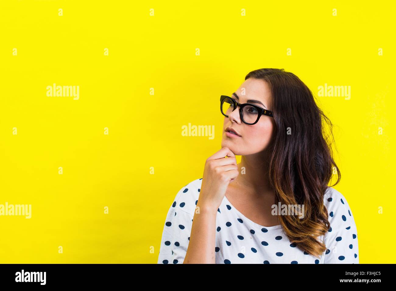 Porträt der jungen Frau hand aufs Kinn in nachdenklicher Pose Stockfoto