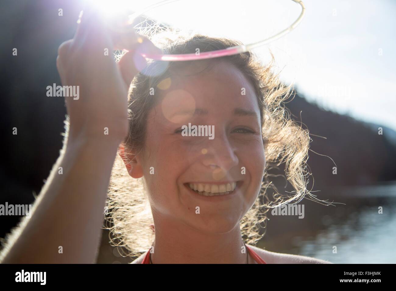 Junge Frau lächelnd in Sonnenlicht Stockfoto Junge Frau lächelnd in Sonnenlicht Stockfoto
