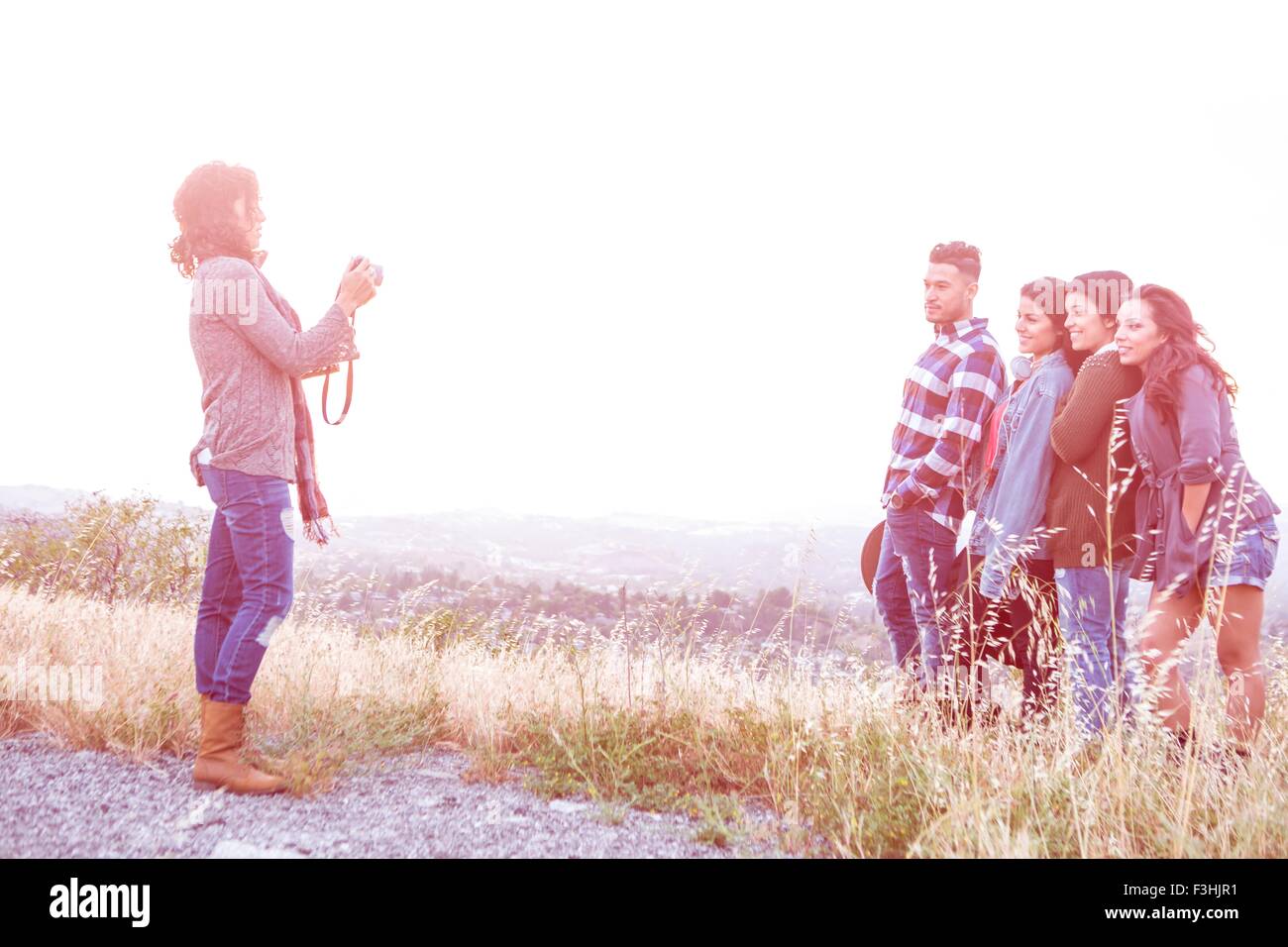 Junge Frau fotografieren ihre vier Erwachsenen Geschwistern auf ländlichen Hügel Stockfoto