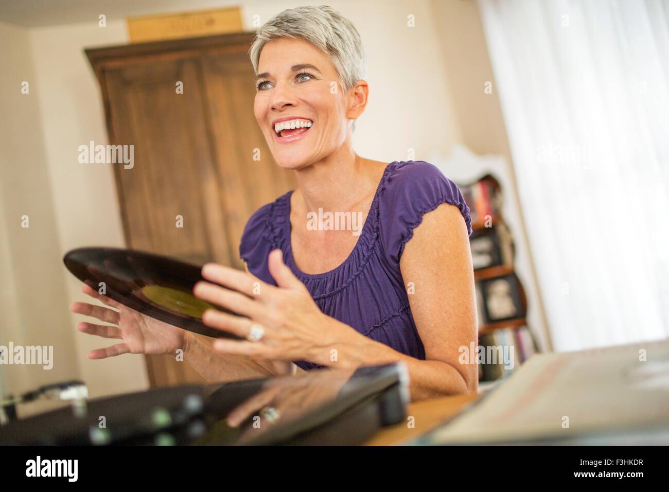 Glücklich Reife Frau spielt Schallplatten Stockfoto