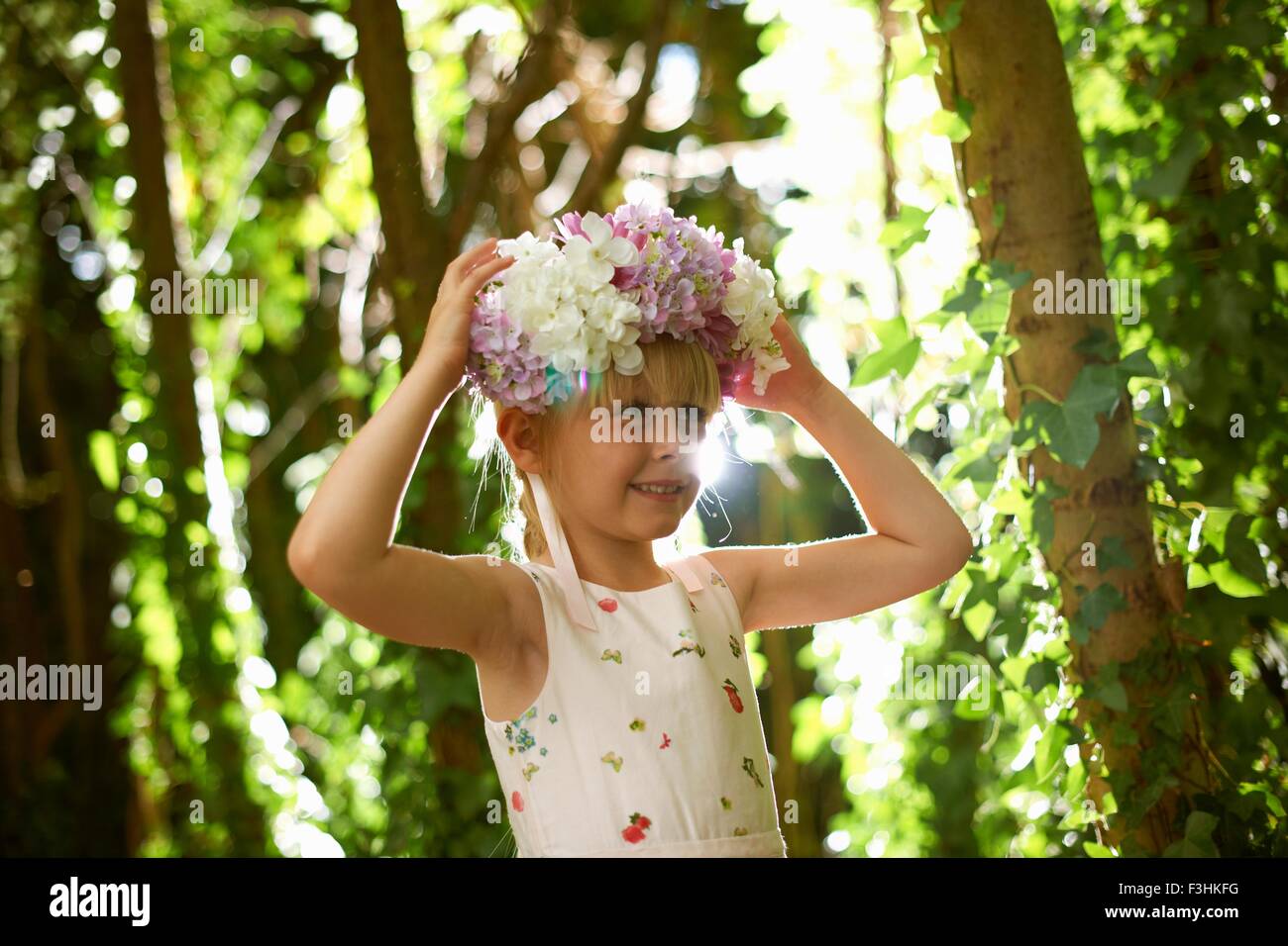 Porträt von hübschen Mädchen tragen Blumen Kopfbedeckung im Wald Stockfoto
