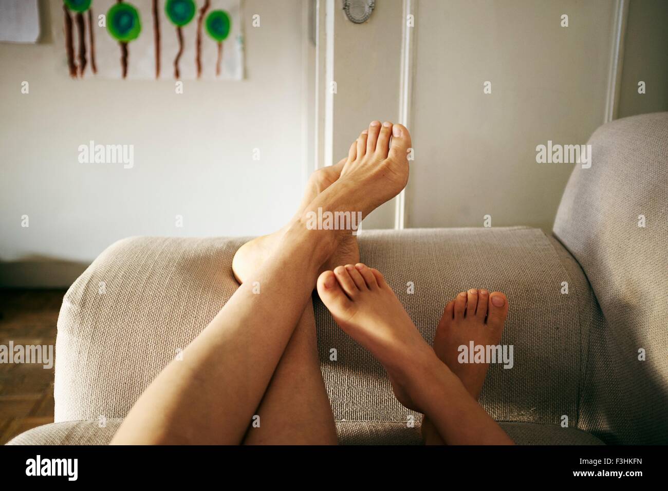 Konzentrieren Sie Mutter und Sohn entspannend auf Sofa und Füße hoch, sich auf Füße Stockfoto